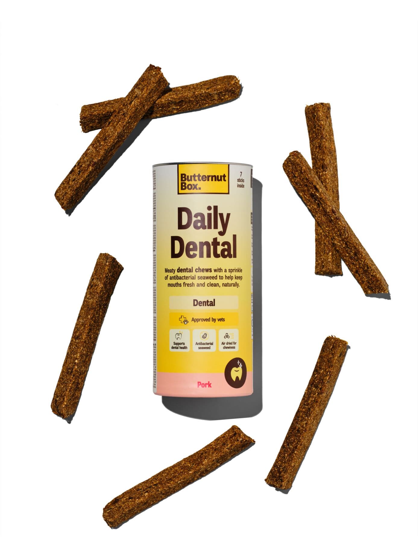 Butternut Box Daily Dental Pork Chews with seven air-dried sticks scattered around the package.